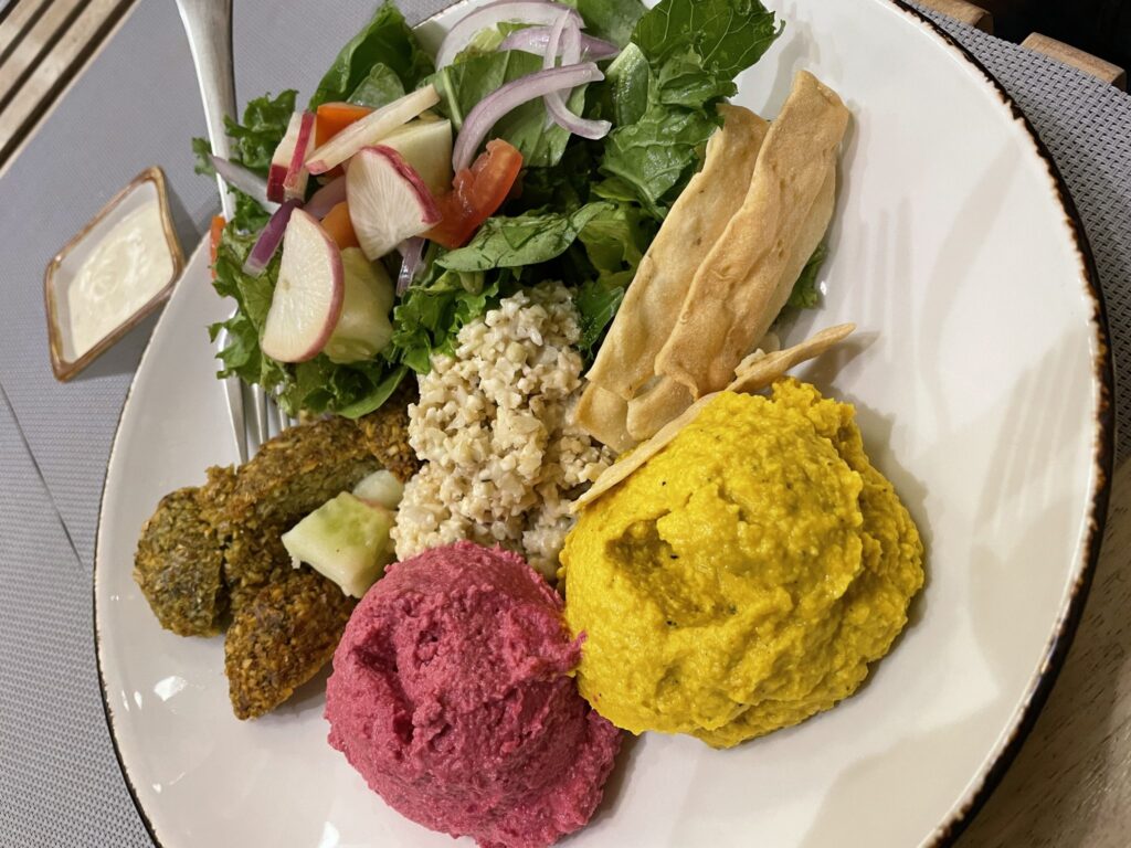 Teller mit Hummus, Falafel, Salat und Rote-Rüben-Creme (KI-generiertes Bild)